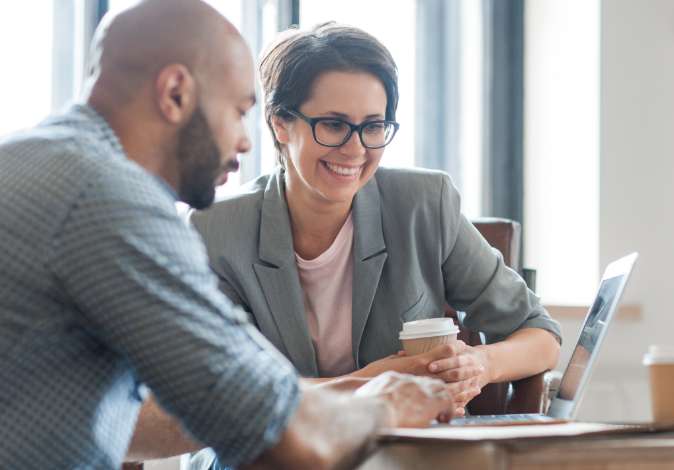 man and woman reviewing report on laptop